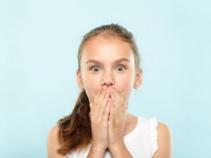 Shocked young girl covering her mouth