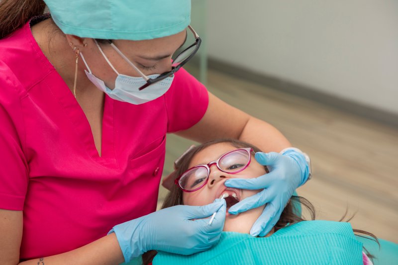 a child receiving fluoride at dentist’s office